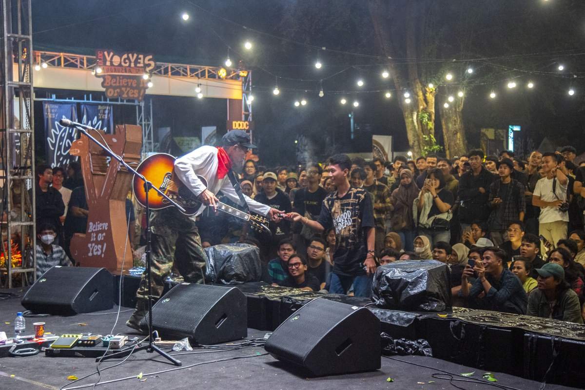 Ikhsan Skuter meminta rkok saat manggung di acara DCDC Yogyes in Absurdum