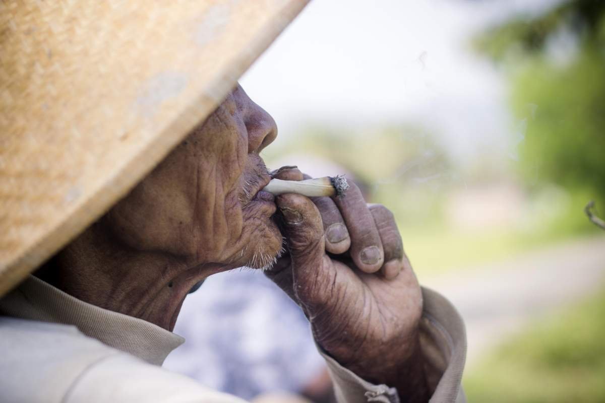 Mbah Sopawiro sedang menikmati Tambakau linting kesukaanya