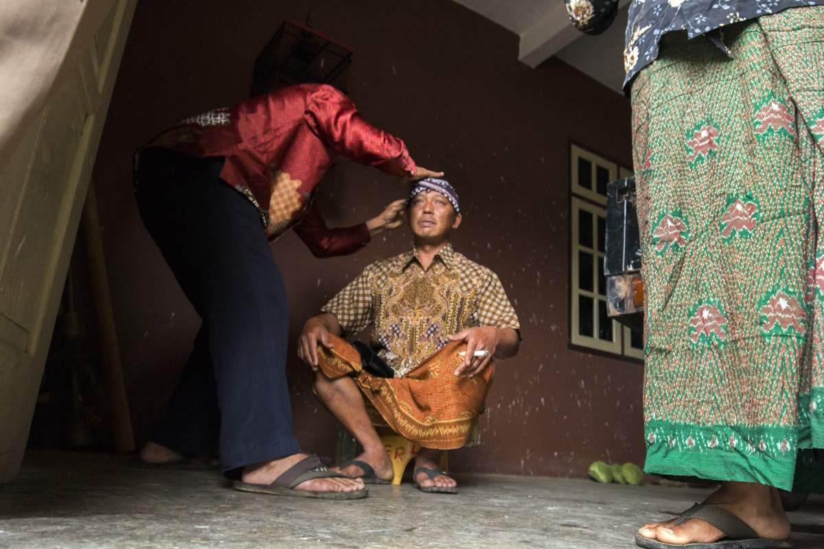 memasang udeng menjelang sadranan