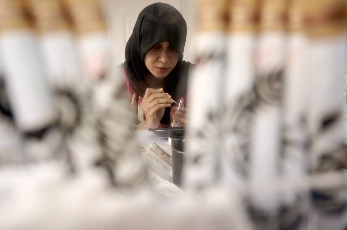 Michelle melukis batangan kretek dengan ampas kopi.