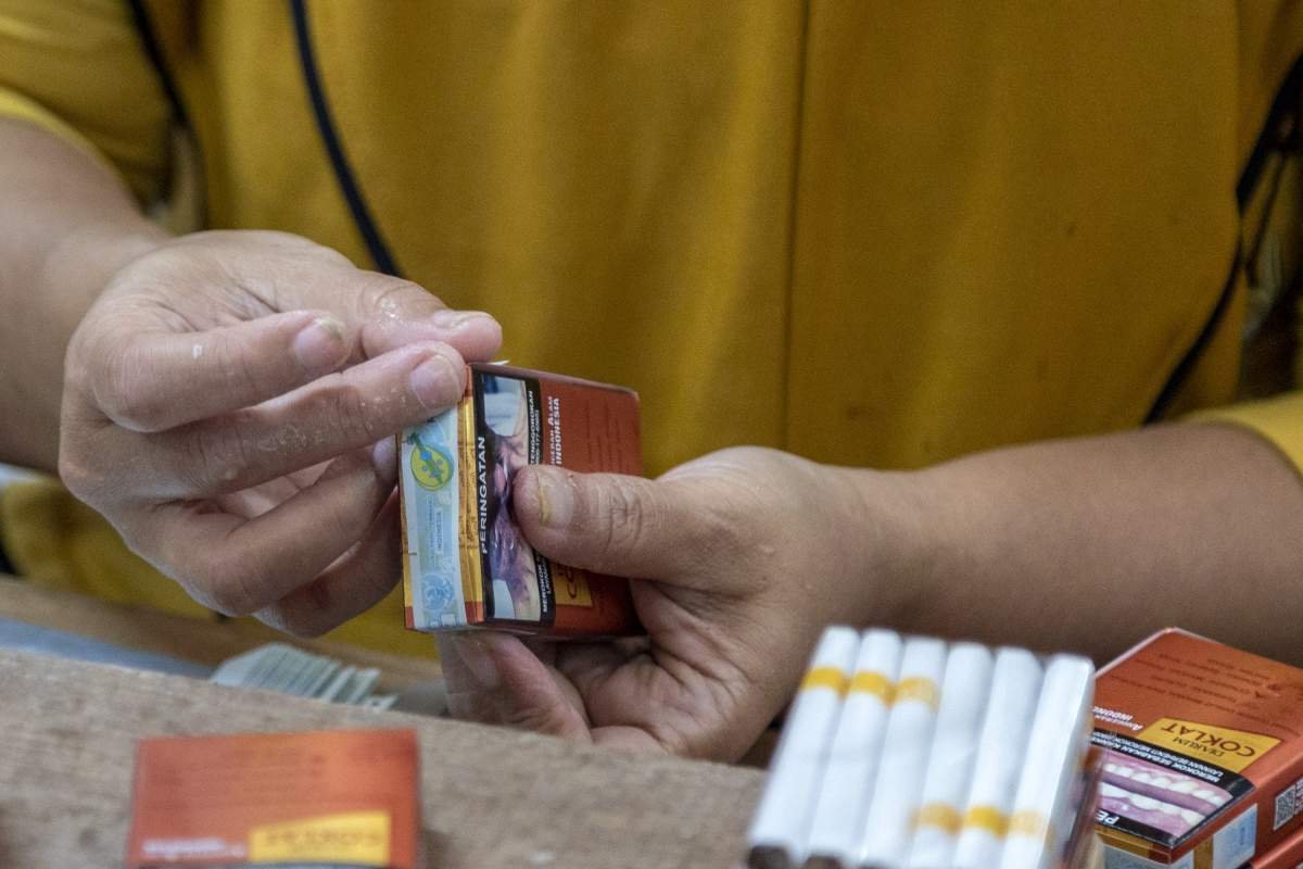 Peerja memasang pita cukai di bungkus rokok kretek Djaum Coklat