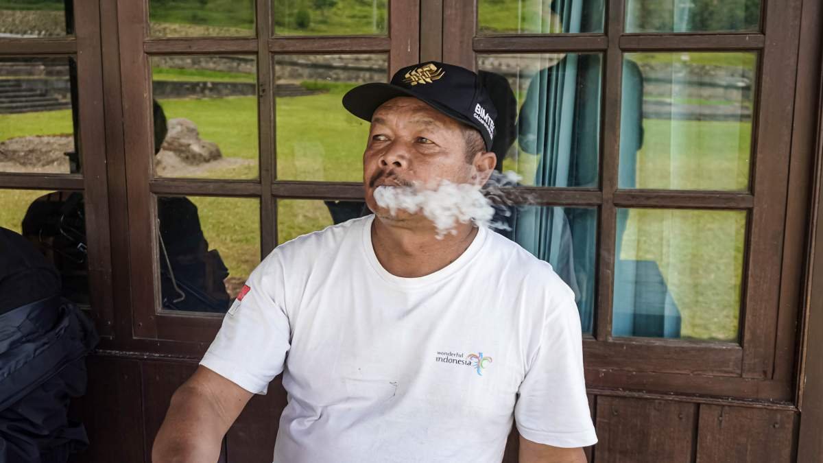 Penjaga Situs Liyangan Sedang Menikmati Sebatang Rokok Kretek