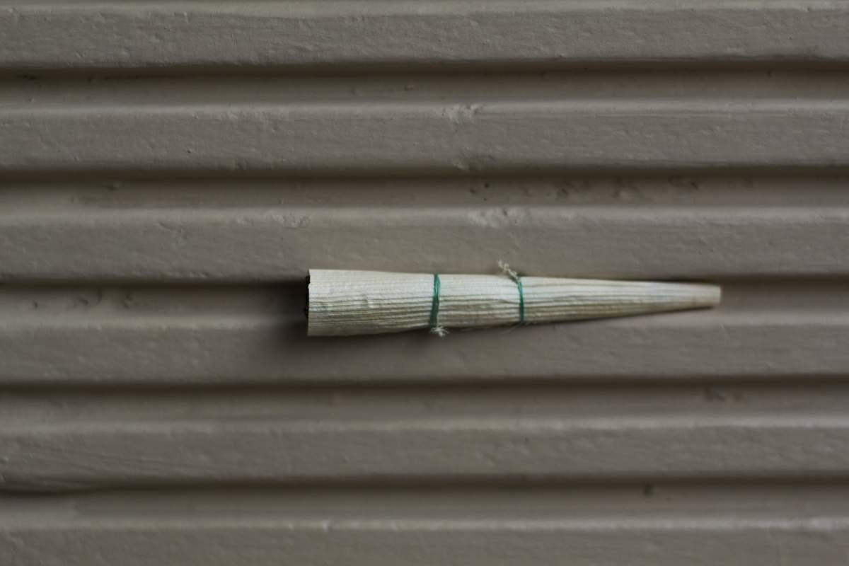 Sebatang klobot terselip di teras rumah