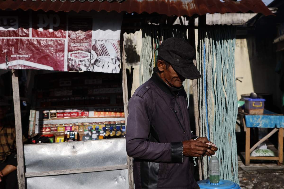 seorang blantik sapi baru saja membeli rokok di pasar hewan siyono